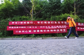 12月5日,中南林业科技大学,学生从雷人的女生节标语前走过。图/实习生杨旭
