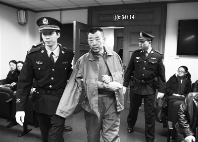 刘书魁被带进法庭。此前,刘书魁因抢劫罪被判处死刑,后又供出新的涉嫌抢劫、致受害人死亡的案情。昨天,其在法院受审。通讯员李佳摄