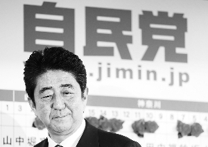 安倍晋三昨日在选举结果牌前微笑。