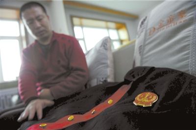 ▲谈到自己申冤过程时,郭学宏深情地抚摸着当年的法官服。本报记者欧阳晓菲摄/视频