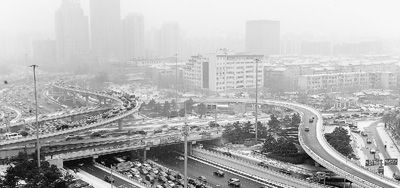 北京,降雪难阻雾霾天。图为12月12日降雪后,雾霾笼罩的西直门桥。 新华社记者 何俊昌摄