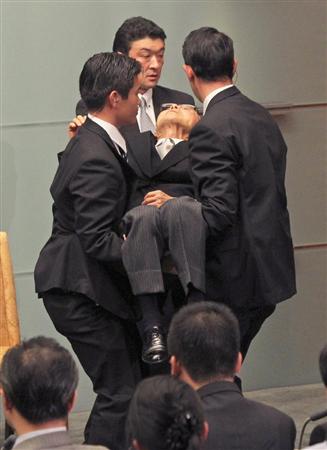 在就任会上,日本官房副长官杉田和博忽然晕倒,引起会场骚动。