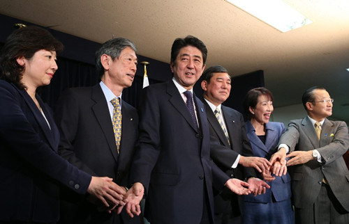 记者会上,安倍与新任的自民党党领导合影留念。