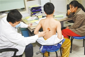 医生正在为男孩伤口消毒。深圳晚报记者 余海洪 摄