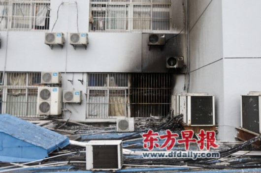 昨日,发生火灾的员工宿舍外墙已被熏得焦黑一片。早报记者 杨一 图