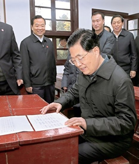 在自己曾经坐过的座位上,胡锦涛仔细看着过去的座次表,并高兴地回忆当年上学时的情景