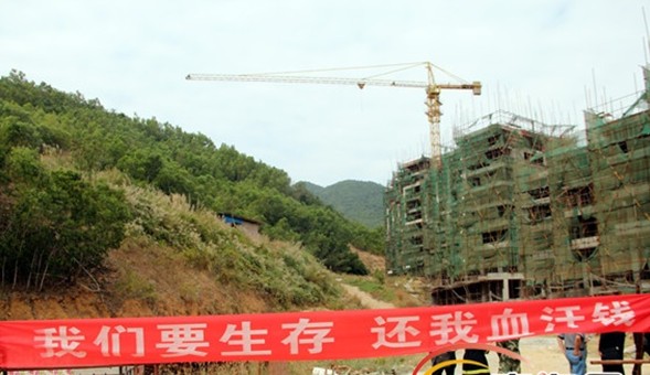 因工地承建方拖欠工资,一名工人爬上工地约40米高的塔吊。图为讨薪现场