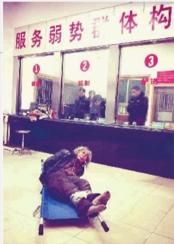 1月7日23点50分,长沙市救助管理站大厅,一名老年流浪者躺在担架上,无助地看着记者。