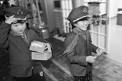 1月11日,浙江杭州,小学生扮演邮递员,在街道里为邮件寻找目的地。