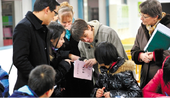 对于感兴趣的题目,几位英国老师正在问一名学生。本报记者盛高摄 data-cke-saved-src=