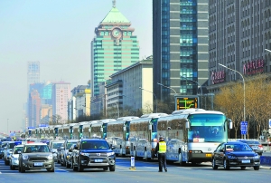 昨天,参加全国政协开幕式的大客车与社会车辆一同在长安街行驶。图为会议用大客车与社会车辆一起等红灯。