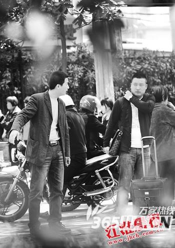 一名黑头车司机正在揽客。丁明 李福凯 摄