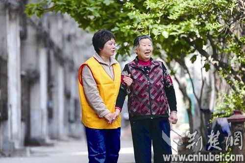 图为:护理人员为老人提供陪伴散步服务